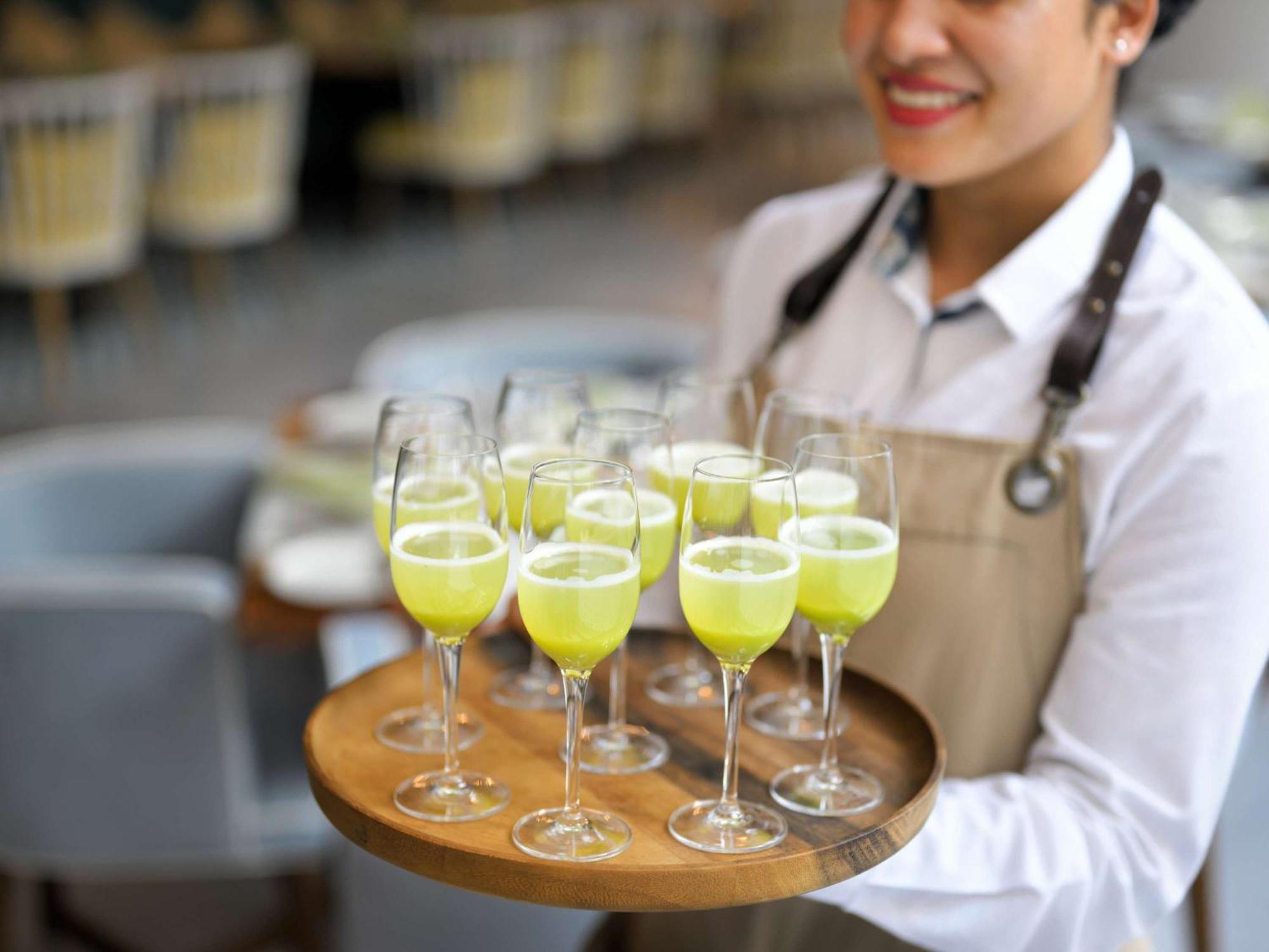 Moevenpick Hotel & Apartments Ghala Muscat Exteriör bild A server holding a tray of cocktails